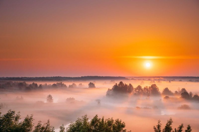 Amazing Sunrise Sunset Over Misty Landscape. Scenic View Of Fogg